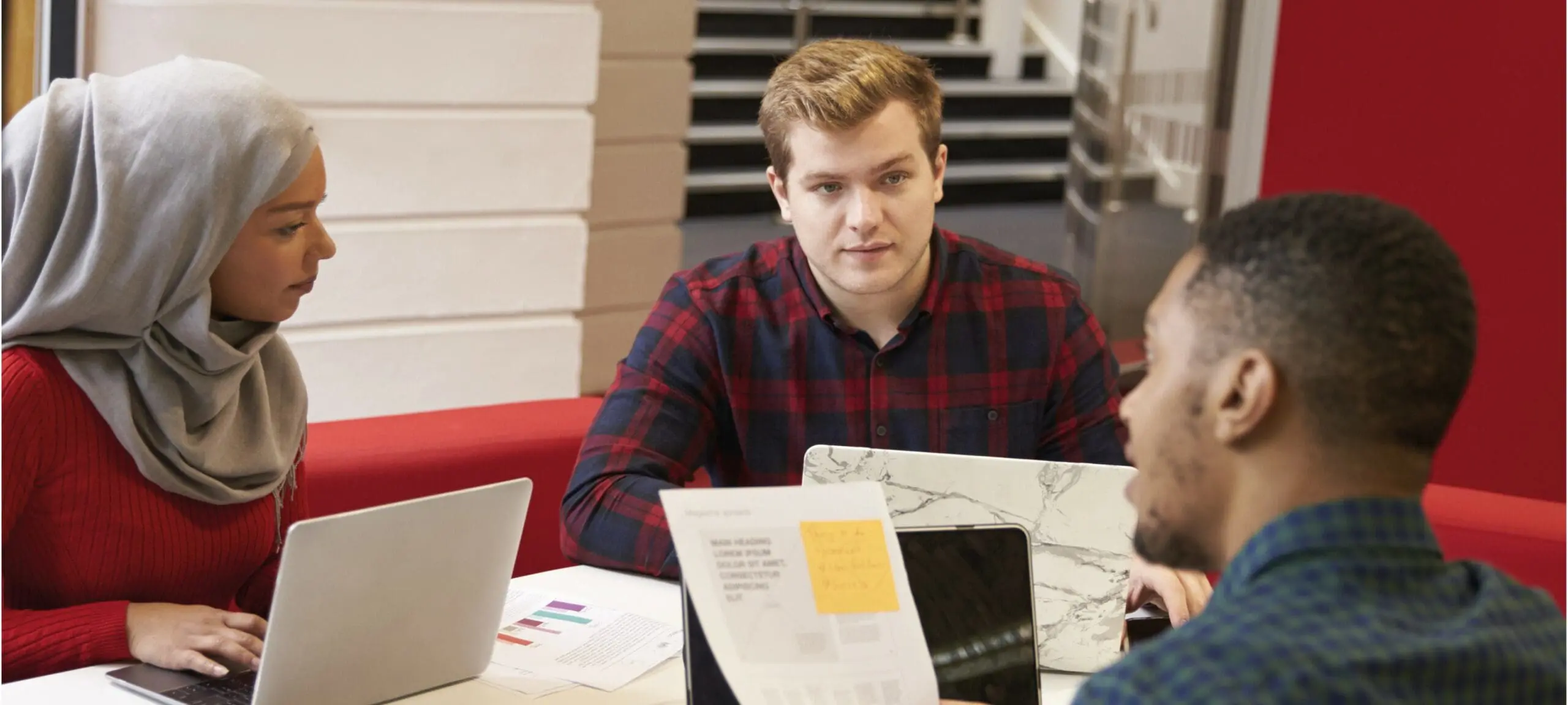 Drie mensen in gesprek in de bibliotheek