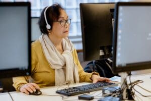 Een ouder Aziatische vrouw werkt op de computer