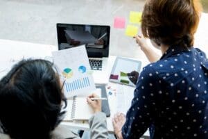 Twee mensen werken achter de computer en bekijken grafieken
