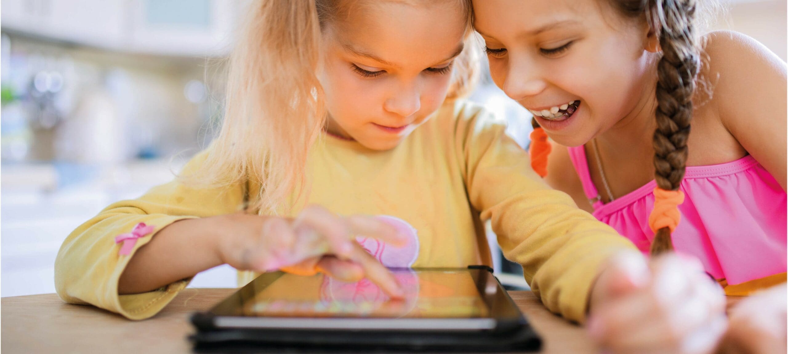 Twee meisjes lezen op een ipad