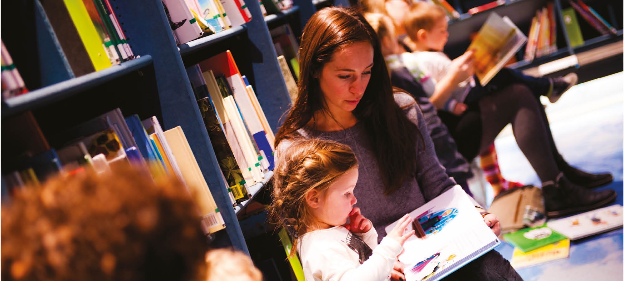 moeder en meisje lezen in de bibliotheek