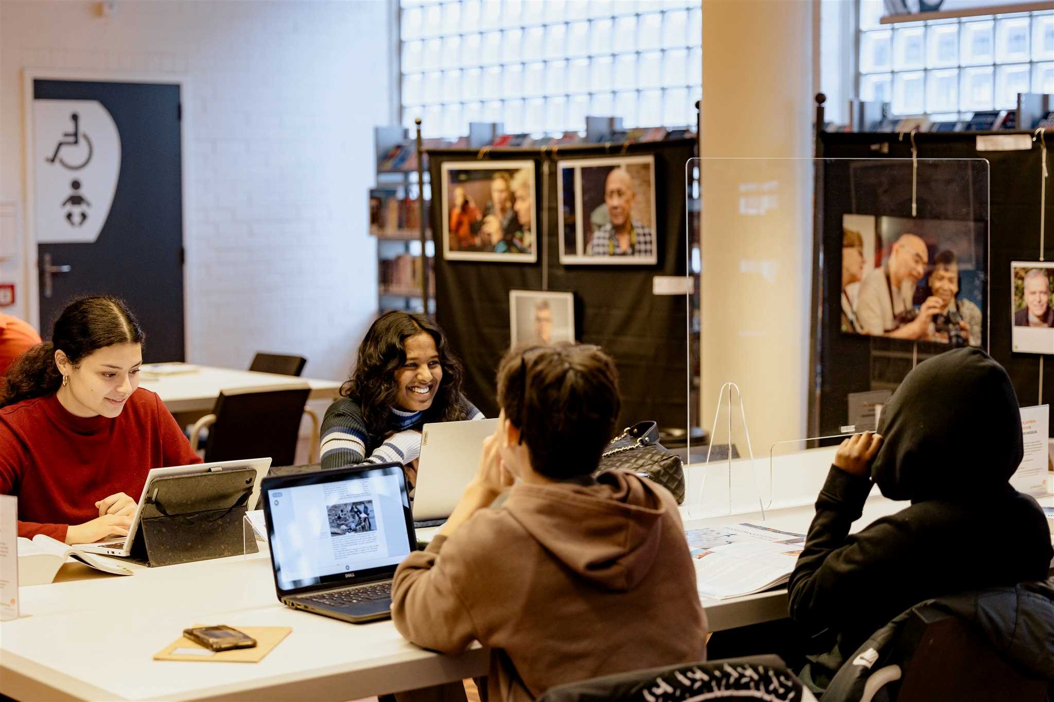 Jongeren werken op laptops in de bibliotheek