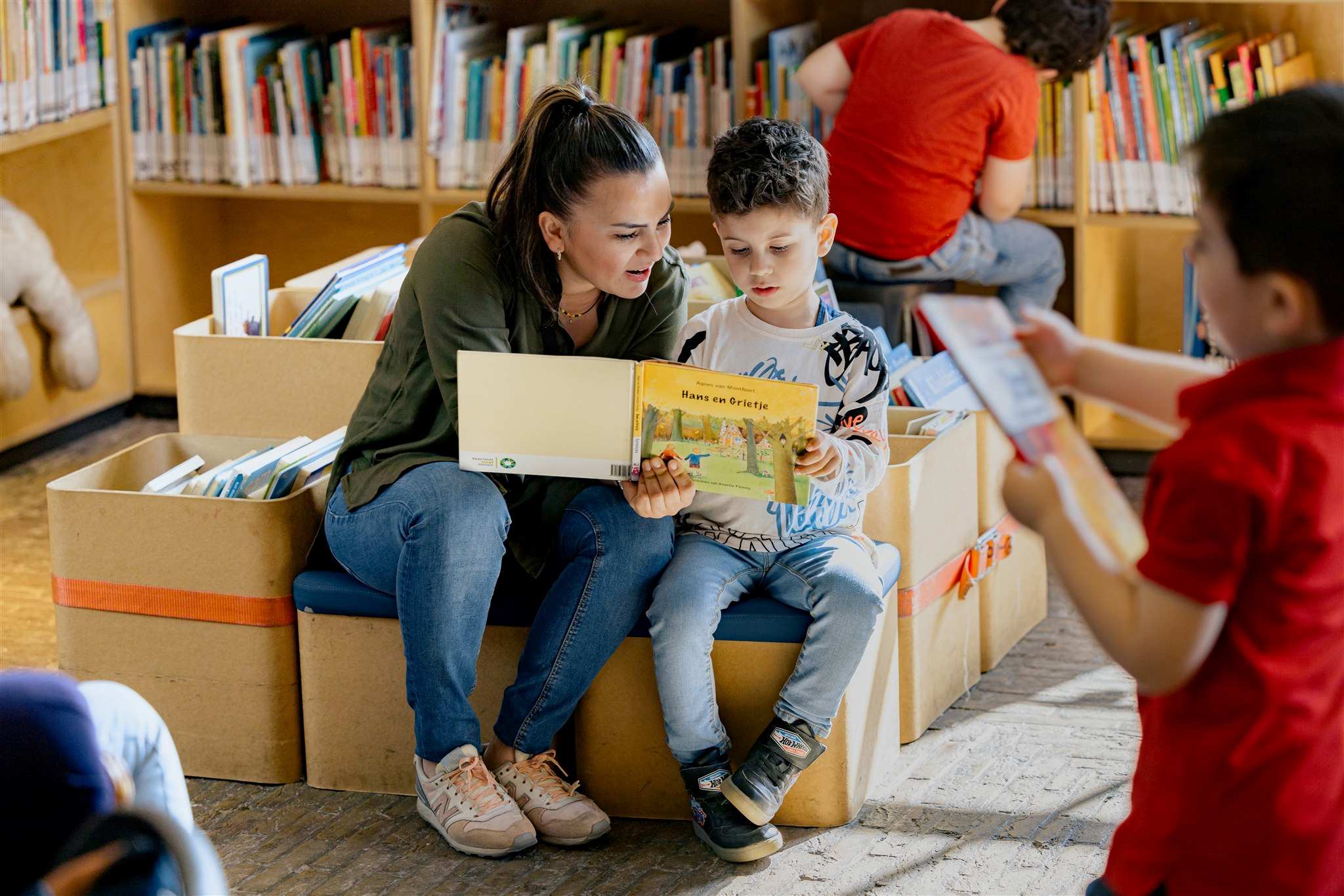 Een moeder leest haar jonge zoon voor in de bibliotheek