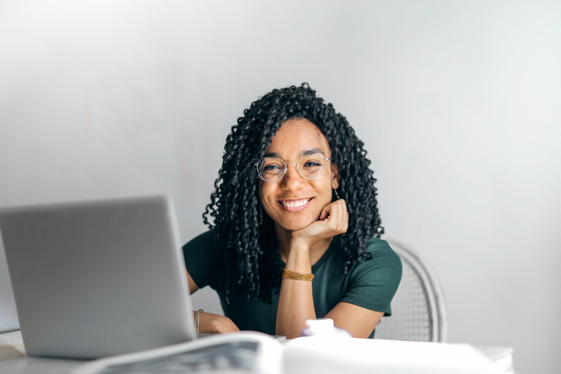 Vrouw glimlacht achter een laptop