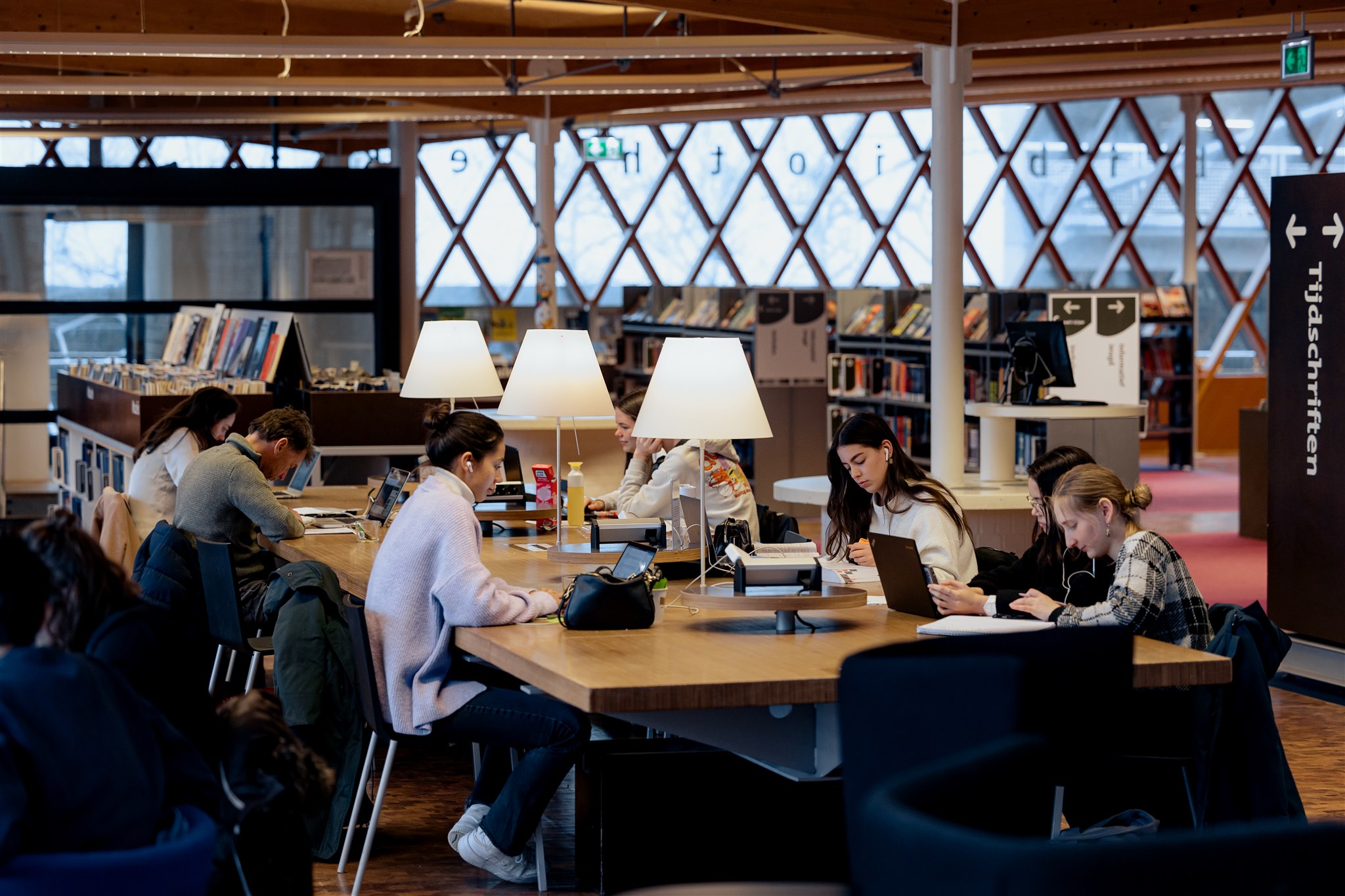 jongeren zitten aan een tafel te studeren in de bibliotheek