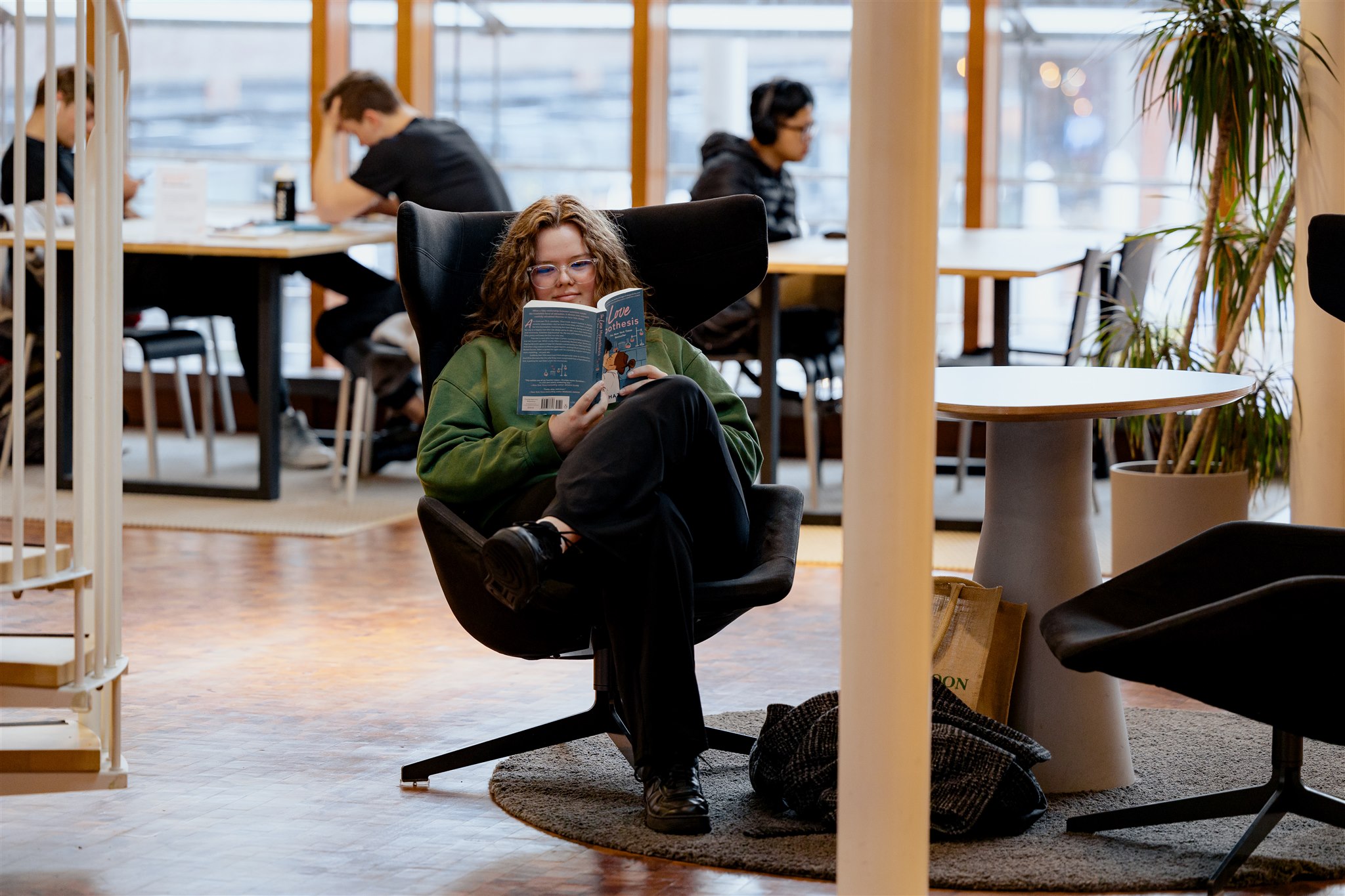 Vrouw leest boek in de bibliotheek