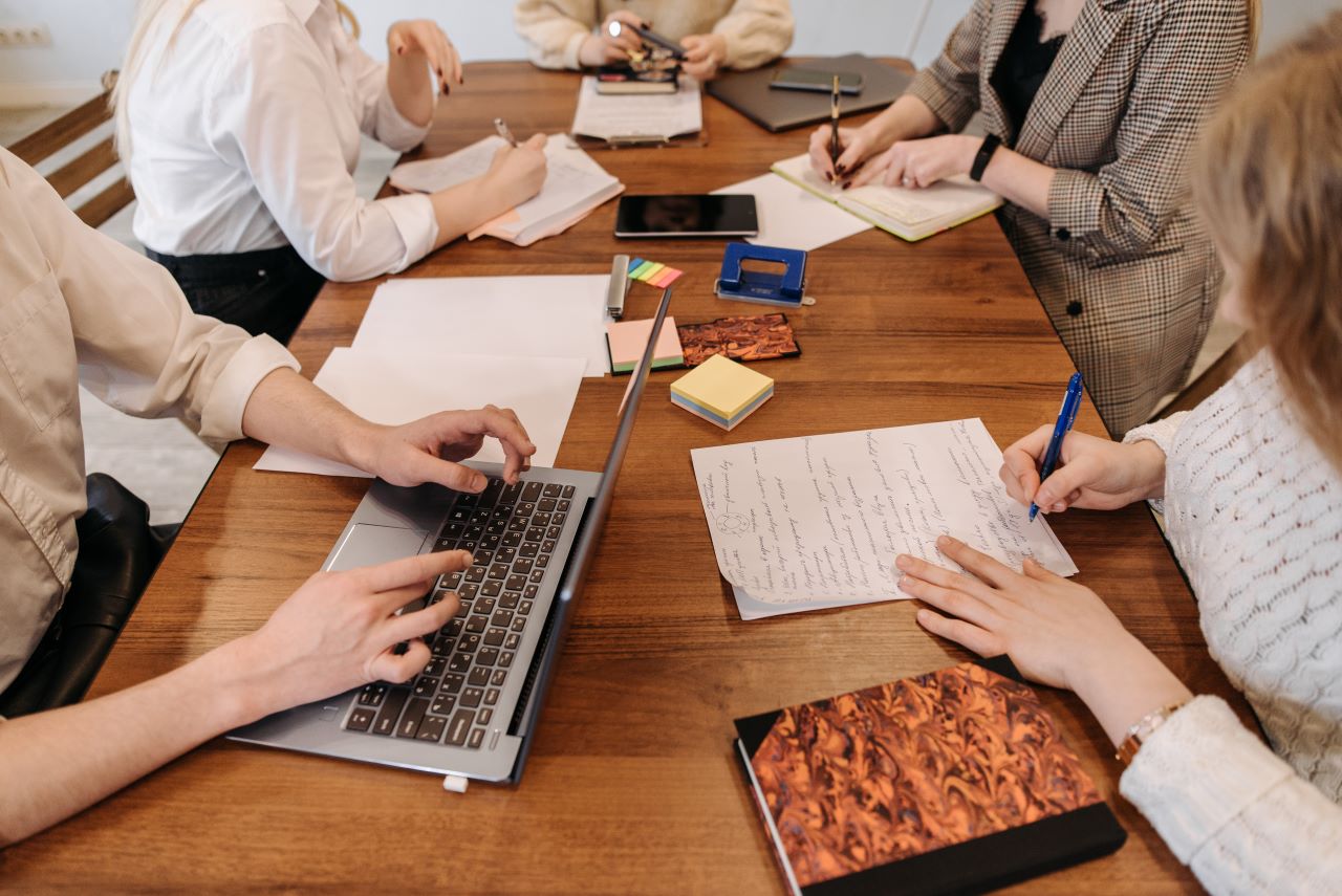 mensen zitten om een tafel met een laptop