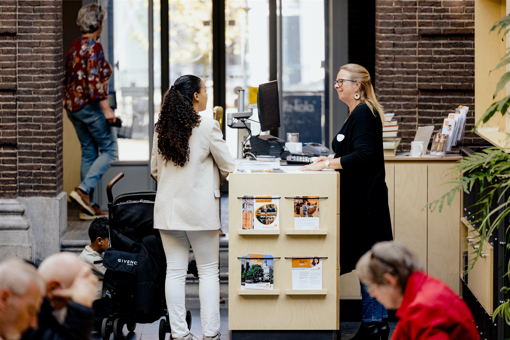 Een medewerker in gesprek met een bezoeker in de bibliotheek